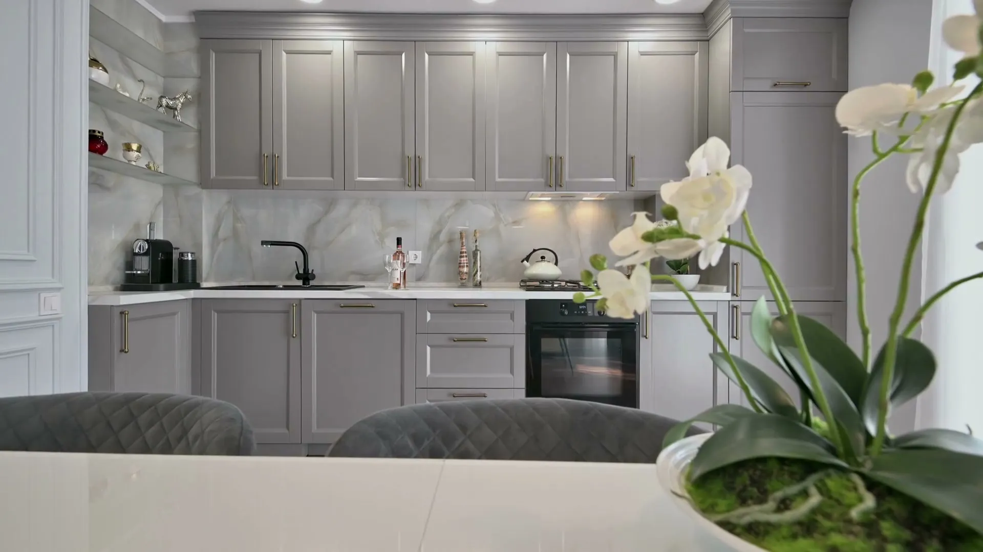 Kitchen with gray shaker cabinets and stone counters